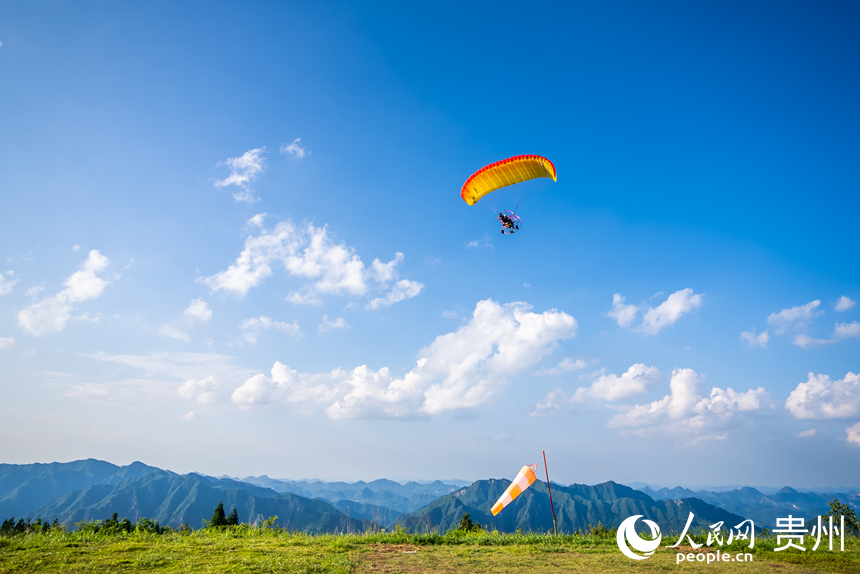 游客在野玉海飛行營地乘動力滑翔傘體驗(yàn)云端觀景。人民網(wǎng)記者 涂敏攝